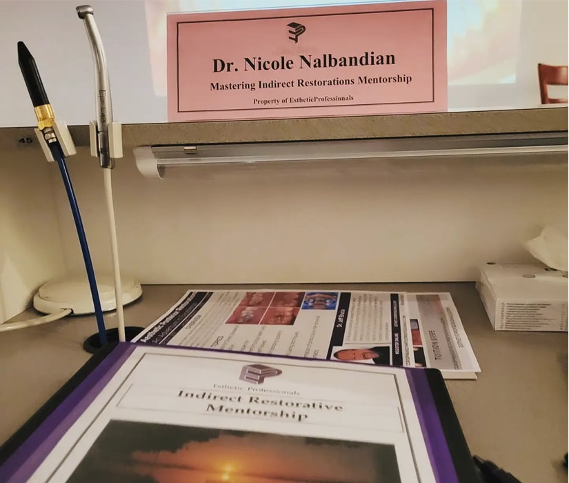 EstheticProfessionals Indirect Restorative Mentorship program materials on desk.