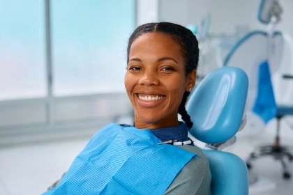 Smiling girl sitting in dentist’s chair during root canal treatment