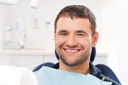 Smiling young man in dentist chair getting gum care