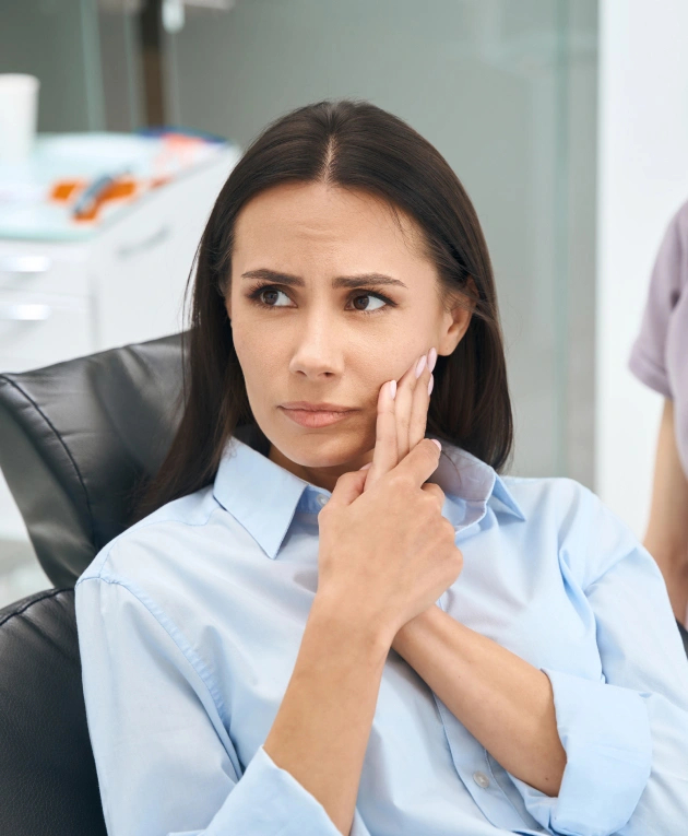 A woman with dental anxiety is seated in a dentist’s chair, awaiting treatment