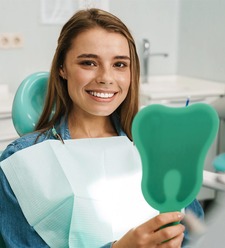 Young girl smiling confidently while sitting in a dentist’s chair in Burbank