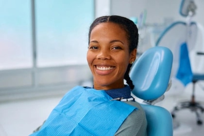 Smiling girl sitting in dentist’s chair during root canal treatment